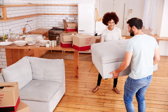 couple moving furniture into new home